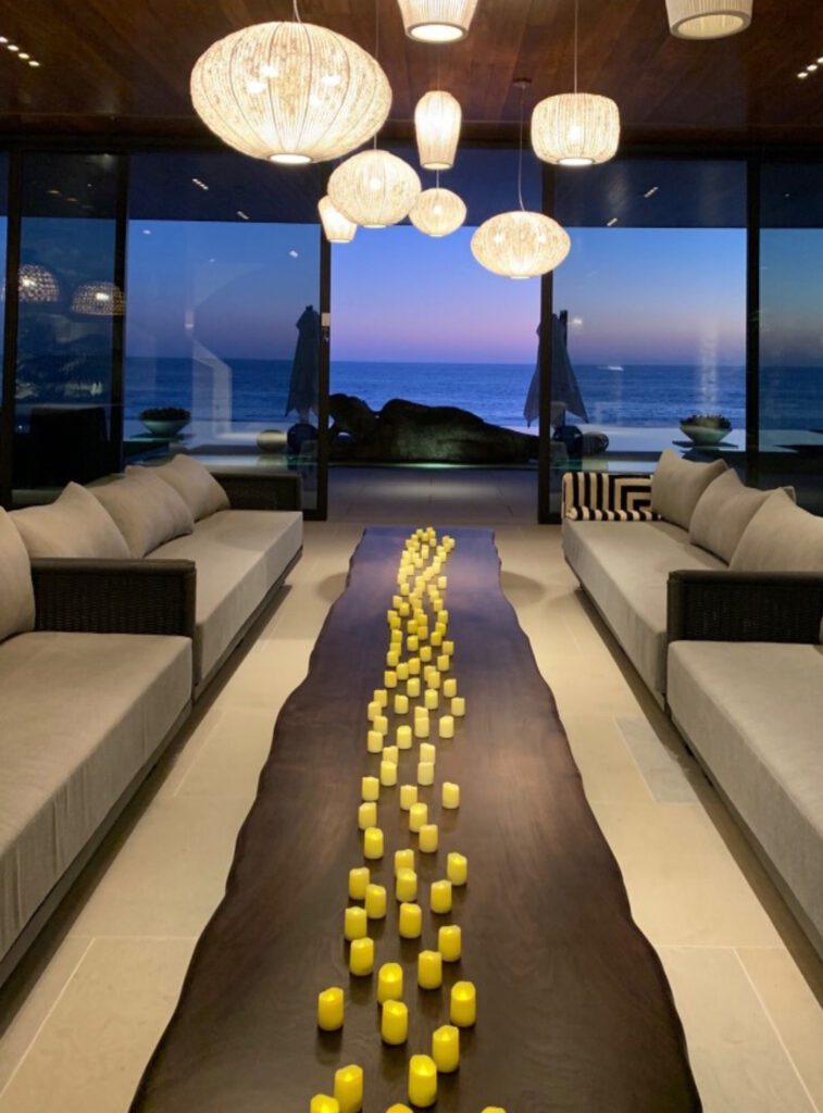 Large entertaining space opens to pool with buddha statue and ocean view at The Strand in Dana Point.